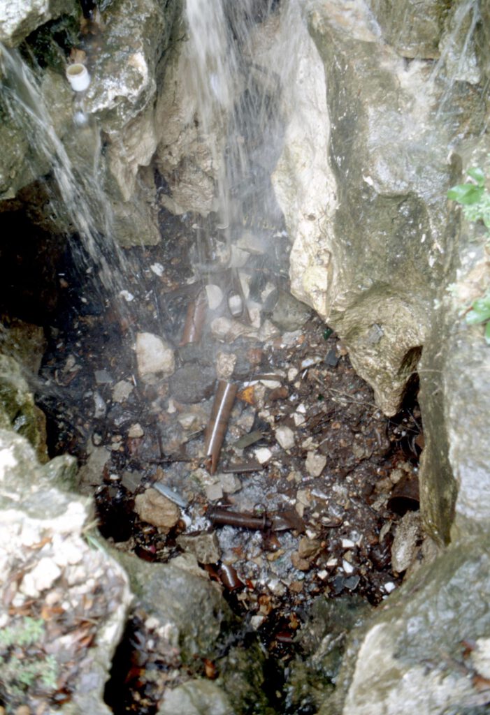 Water flows into a trash-filled cave before reaching the aquifer. Photo: NCKRI-George Veni