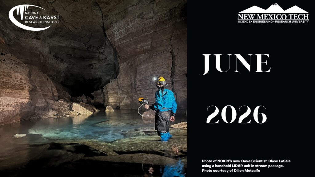 a person with a helmet and cave suit in a cave passage full of water to the person's ankles. The person is holding a LIDAR unit. The NCKRI logo, NMT logo and text saying June 2026